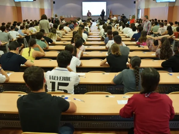 Estudiantes en aula universitaria durante una conferencia o clase.